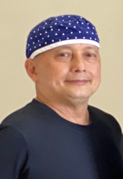 Martin Altonaga, dental assistant at Quibilan Dentistry, in navy scrubs and a polka-dot cap.