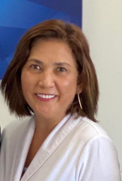 Mila Quibilan, office manager at Quibilan Dentistry, smiling in a white coat.